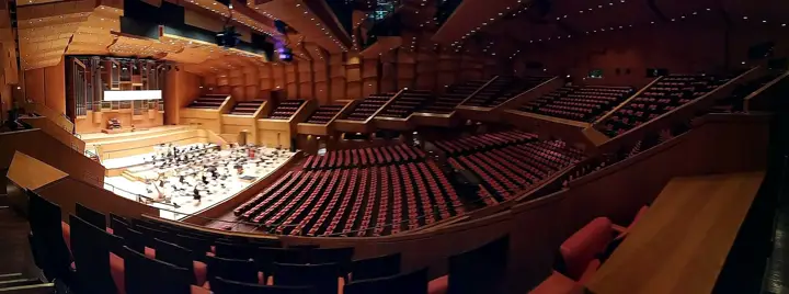 Megaron, the orchestra on stage and the surtitle screen above.
