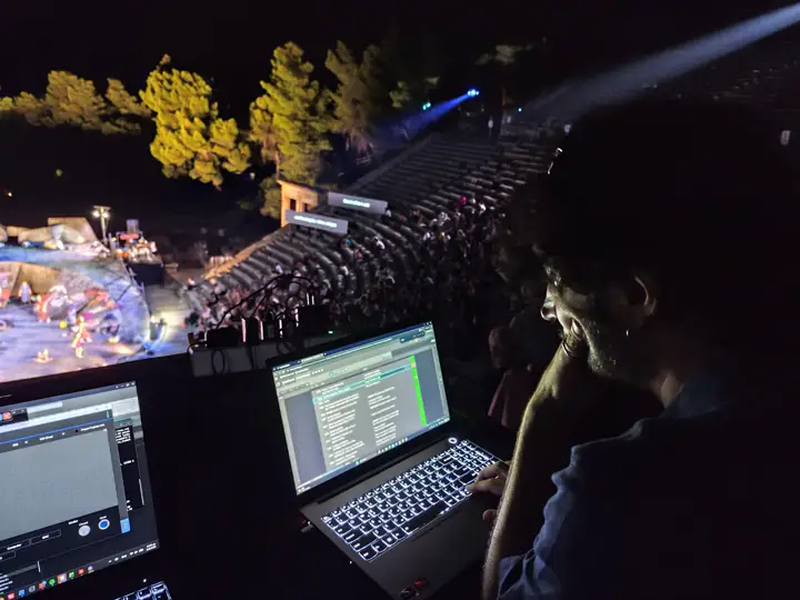 Cueing from a laptop beside an open-air theatre.