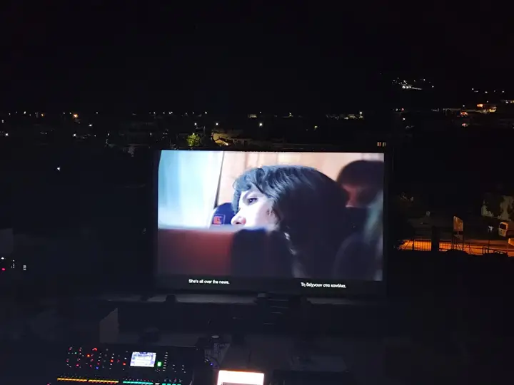 Titles on an outdoor screen, two languages on one picture.